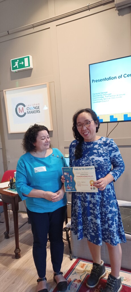 Two women, one holding a certificate.